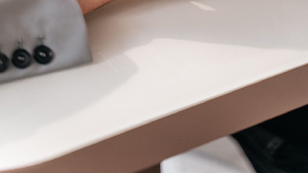 A younger hand and an older hand holding gently across a table