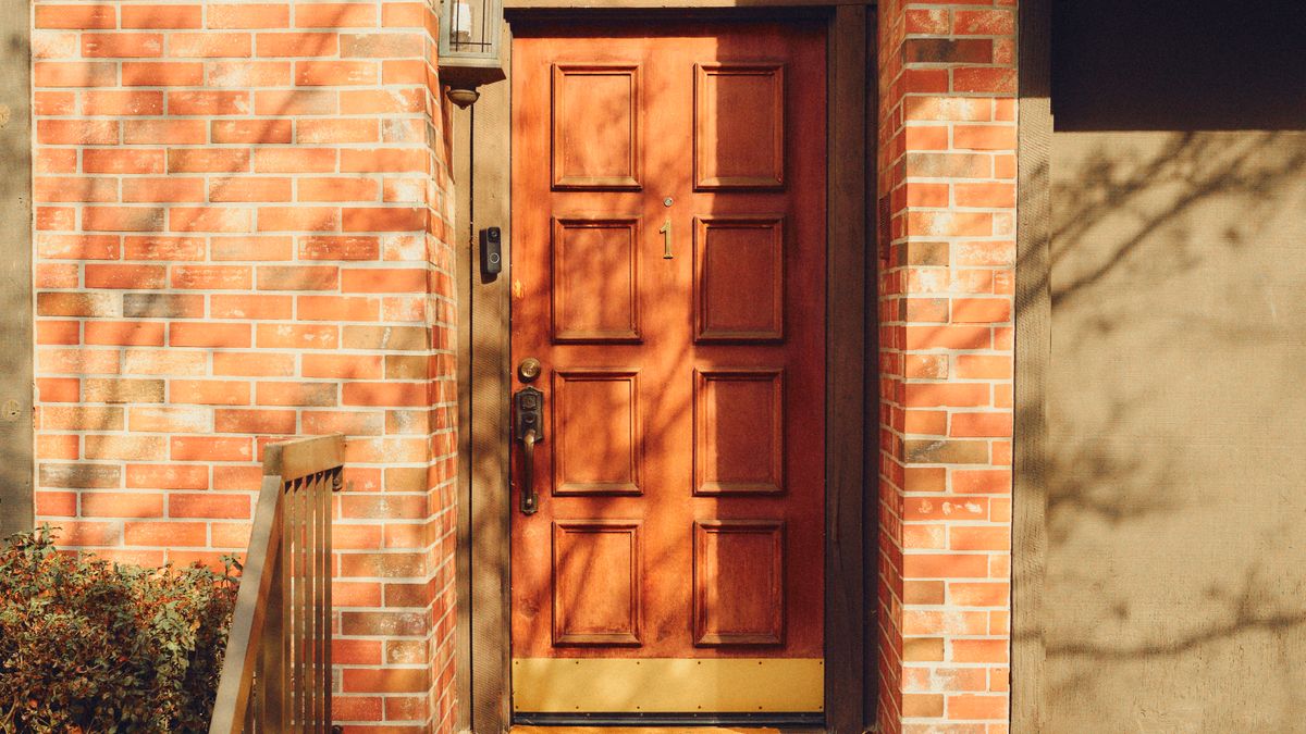 A warm wooden front door with handrails at the steps, the kind of home a family weighs the cost of senior care to keep