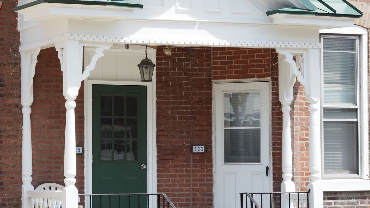 A well-kept brick home with porch handrails at the entry steps, the kind of accessibility change that helps a senior keep living at home