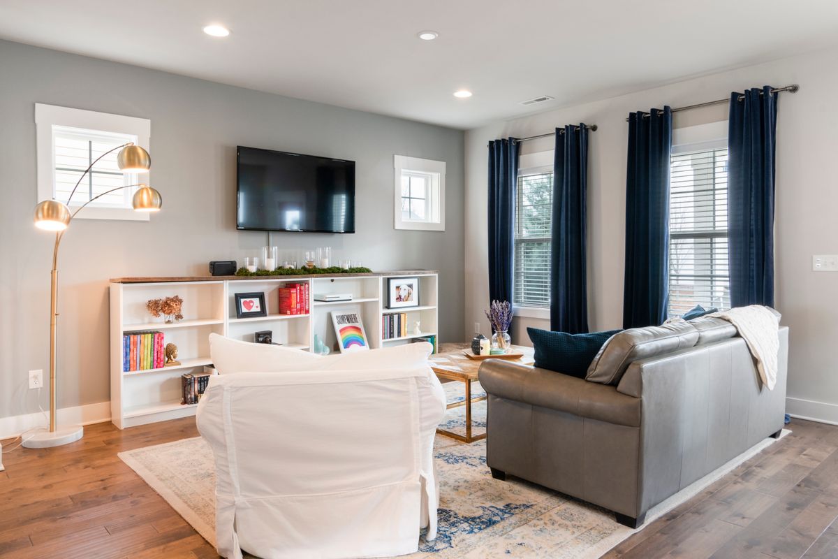 A bright, comfortable living room with blinds and curtains at the windows to manage the sun and heat