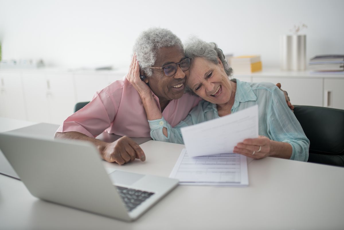 An older couple reviewing their finances together at home, calmly planning ahead for the cost of long-term care