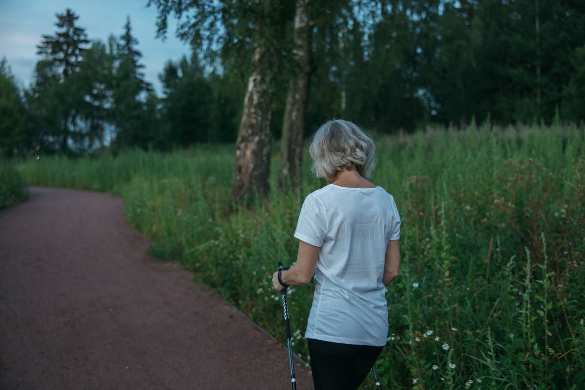 An older woman staying active with a brisk walk outdoors